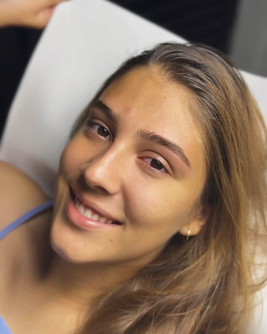 Cliente sorrindo com sobrancelhas desenhadas